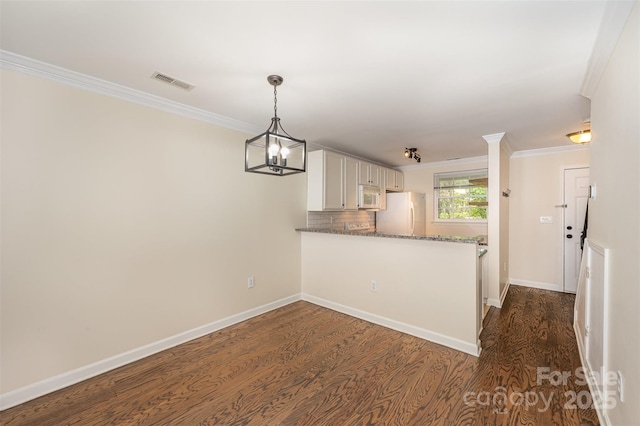 kitchen featuring dark stone countertops, visible vents, ornamental molding, white appliances, and dark wood-type flooring
