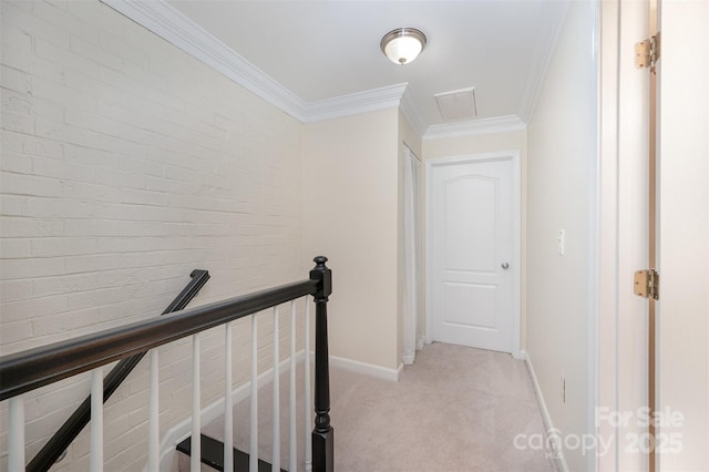 corridor featuring light colored carpet, baseboards, ornamental molding, and an upstairs landing