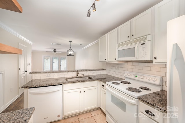 kitchen featuring a sink, white cabinets, white appliances, and a peninsula