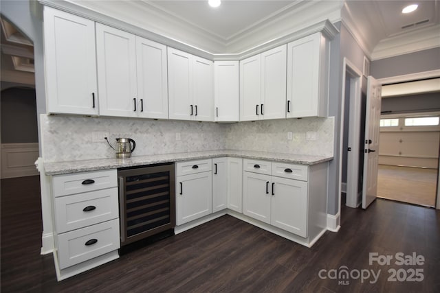 6519 Pargo Rd, Charlotte, NC 28216 - kitchen featuring ornamental molding, decorative backsplash, wine cooler, dark wood-type flooring, and white cabinetry
