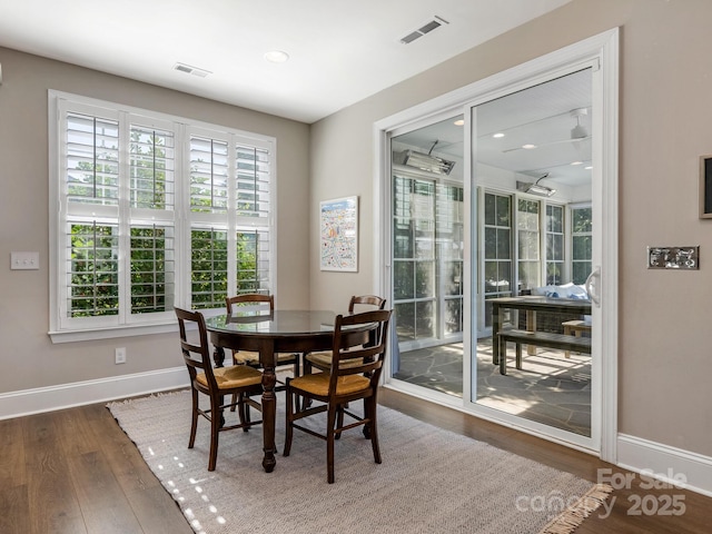 dining room featuring visible vents, baseboards, and wood finished floors