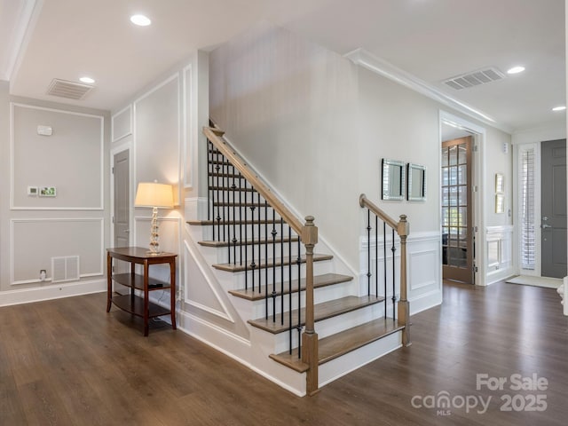 stairs featuring a decorative wall, visible vents, and recessed lighting