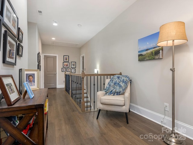sitting room with baseboards, recessed lighting, an upstairs landing, attic access, and wood finished floors
