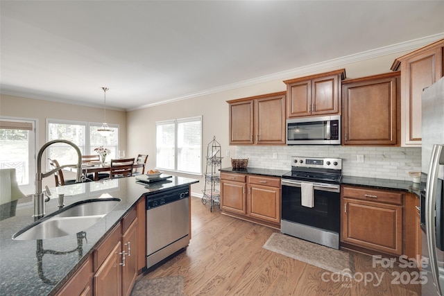 985 Angelica Ln, Tega Cay, SC 29708 - kitchen featuring brown cabinetry, light wood-style floors, a sink, dark stone countertops, and appliances with stainless steel finishes