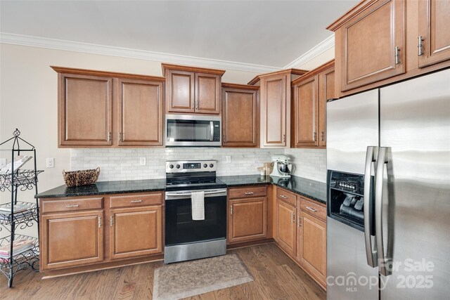985 Angelica Ln, Tega Cay, SC 29708 - kitchen featuring backsplash, crown molding, appliances with stainless steel finishes, brown cabinets, and dark wood-style floors