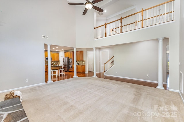 6941 Augustine Way, Charlotte, NC 28270 - unfurnished living room featuring a high ceiling, decorative columns, ceiling fan, baseboards, and stairs