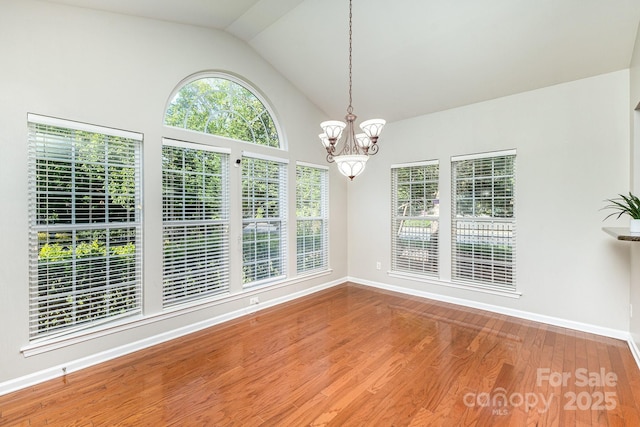 6941 Augustine Way, Charlotte, NC 28270 - unfurnished dining area featuring a chandelier, wood finished floors, baseboards, and vaulted ceiling