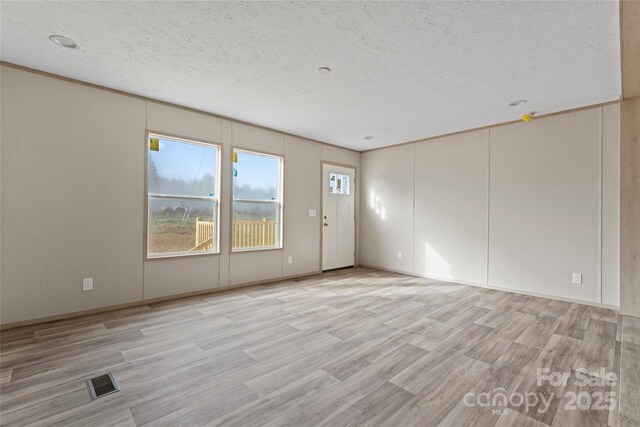 5989 Kaylas Ridge Rd, Connelly Springs, NC 28612 - unfurnished room with light wood-style floors and a textured ceiling