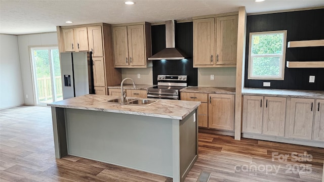 5989 Kaylas Ridge Rd, Connelly Springs, NC 28612 - kitchen featuring wall chimney range hood, stainless steel appliances, light countertops, a kitchen island with sink, and light wood-style flooring