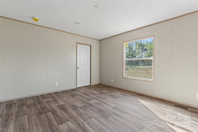 5989 Kaylas Ridge Rd, Connelly Springs, NC 28612 - empty room with light wood-style flooring, a smoke detector, and a decorative wall