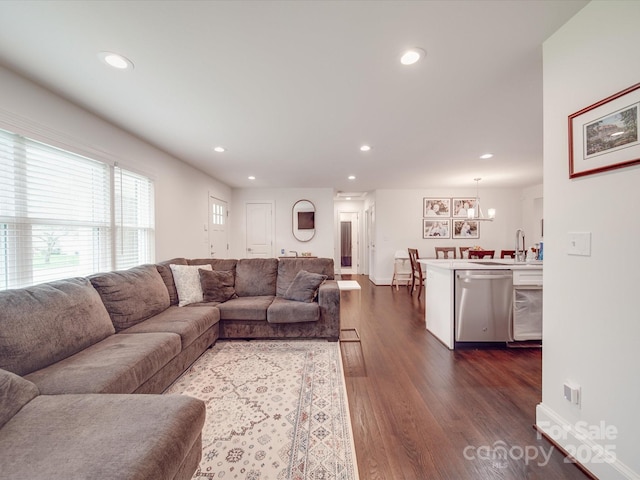 living room with recessed lighting, baseboards, and dark wood-type flooring
