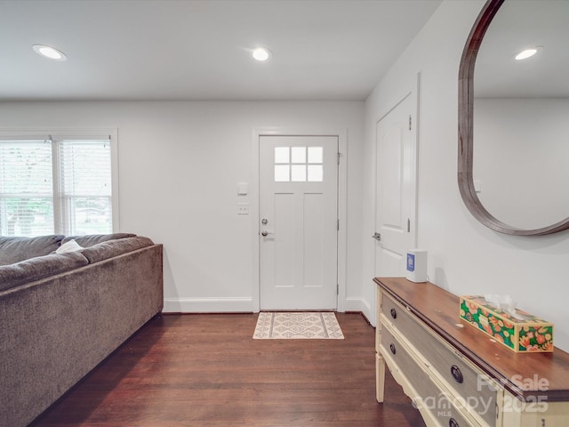 foyer featuring arched walkways, baseboards, dark wood-type flooring, and recessed lighting