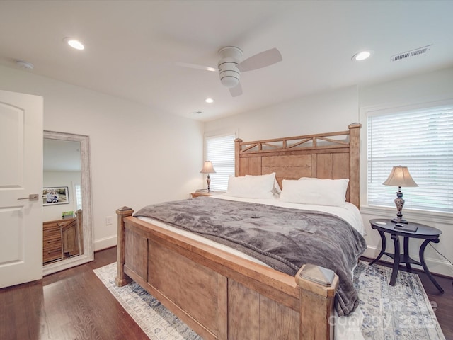 bedroom featuring visible vents, dark wood finished floors, and multiple windows