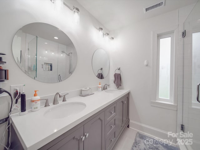 full bath with visible vents, a sink, double vanity, and a stall shower