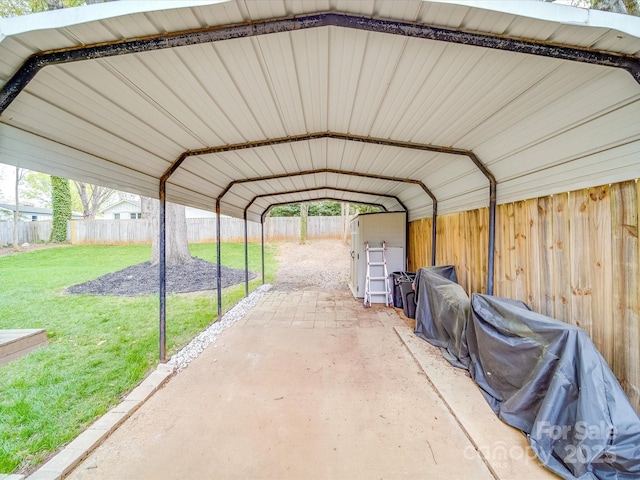 view of parking / parking lot with a carport and a fenced backyard