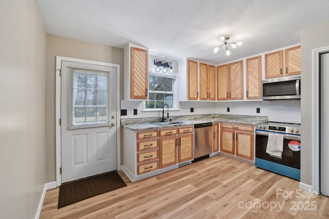 510 Laurel St, Hendersonville, NC 28792 - kitchen with an inviting chandelier, a sink, light wood-style floors, a textured ceiling, and stainless steel appliances