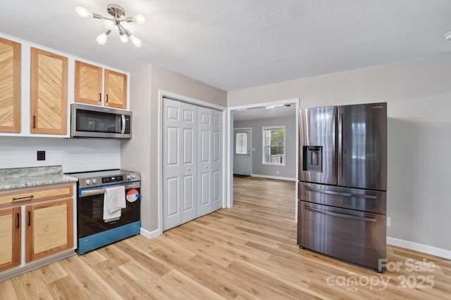 510 Laurel St, Hendersonville, NC 28792 - kitchen with light wood-style flooring, light brown cabinets, baseboards, and stainless steel appliances