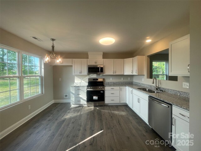58 Simpson Rd, Pageland, SC 29728 - kitchen featuring appliances with stainless steel finishes, a sink, white cabinetry, baseboards, and light stone countertops