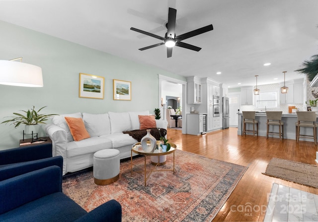 living room with recessed lighting, light wood-style floors, and a ceiling fan