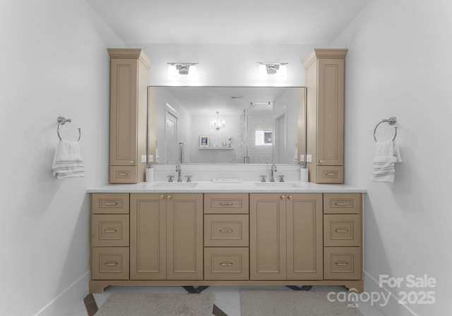 bathroom with double vanity, baseboards, and a sink
