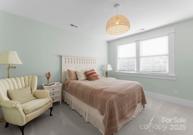 bedroom featuring visible vents, baseboards, and light carpet