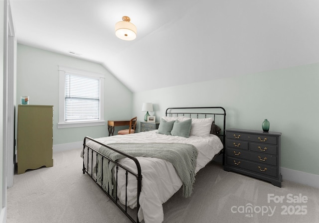 carpeted bedroom with lofted ceiling and baseboards