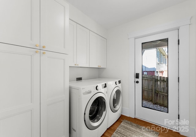 clothes washing area with washing machine and dryer, dark wood-style floors, and cabinet space