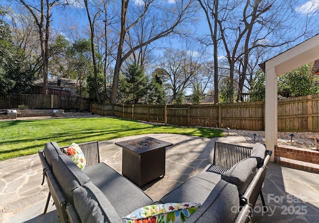 view of patio / terrace with a fenced backyard and an outdoor living space with a fire pit