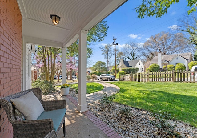 view of patio / terrace with covered porch, a residential view, and fence
