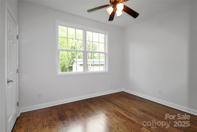 unfurnished room featuring visible vents, ceiling fan, baseboards, and dark wood finished floors