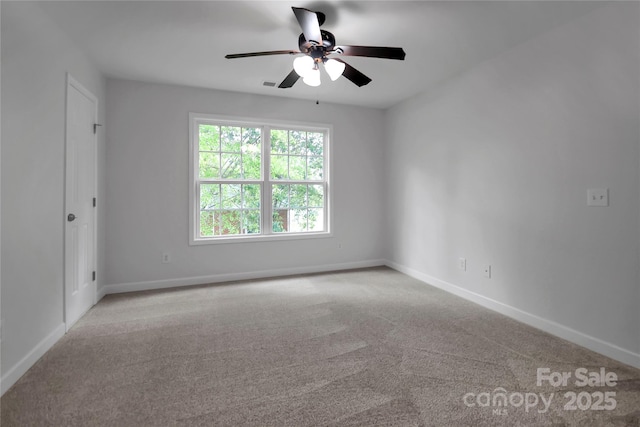 carpeted spare room with baseboards and a ceiling fan