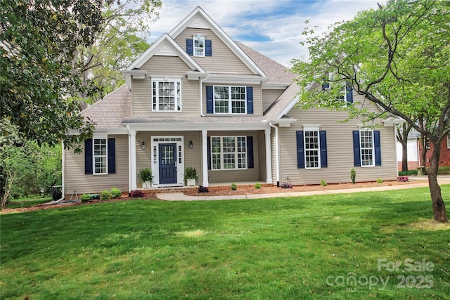 view of front of property featuring a front lawn and a shingled roof