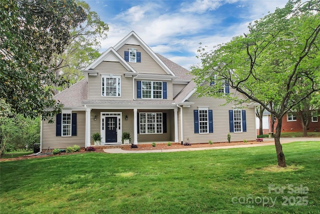 view of front of property featuring a front yard and roof with shingles