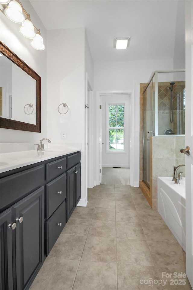 bathroom featuring a shower stall, a bath, double vanity, and tile patterned floors