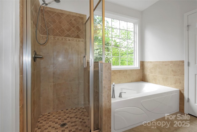 bathroom with a shower stall and a bath