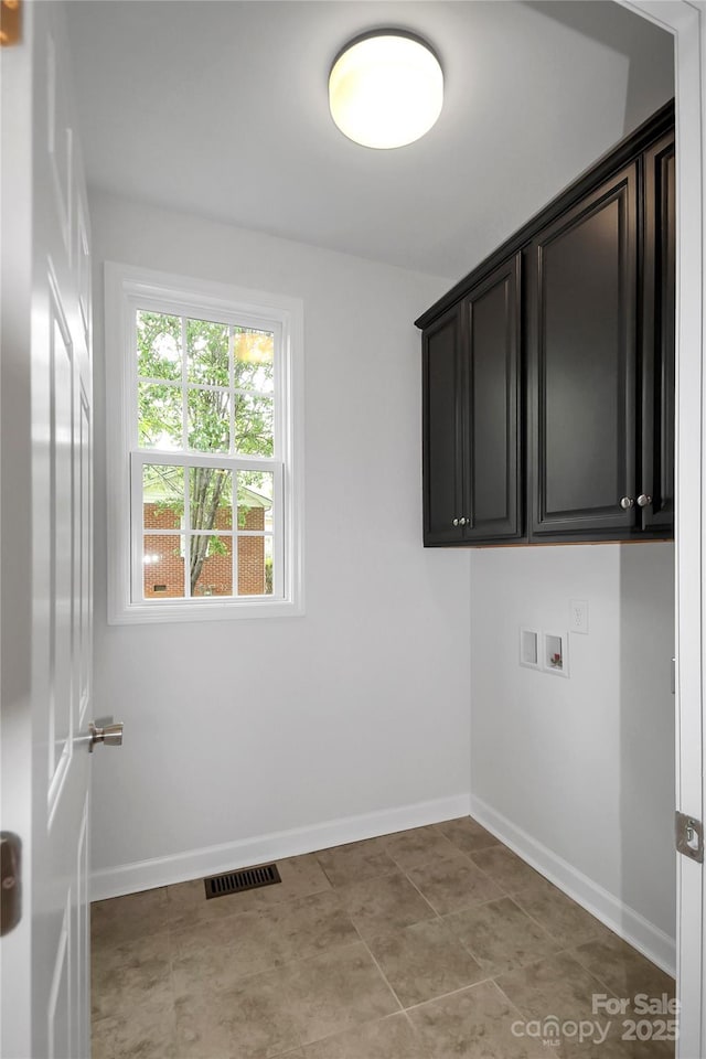 laundry room featuring baseboards, visible vents, washer hookup, and cabinet space