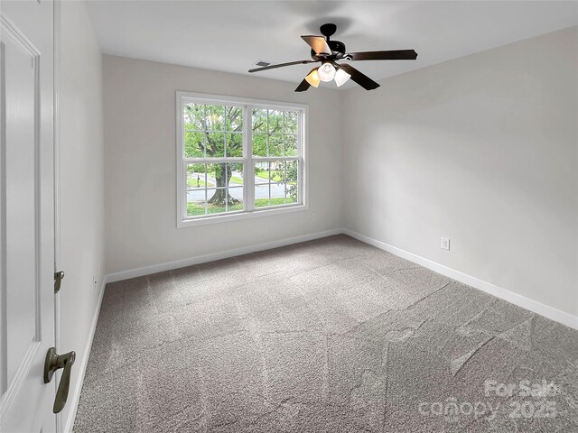spare room with carpet floors, baseboards, and a ceiling fan