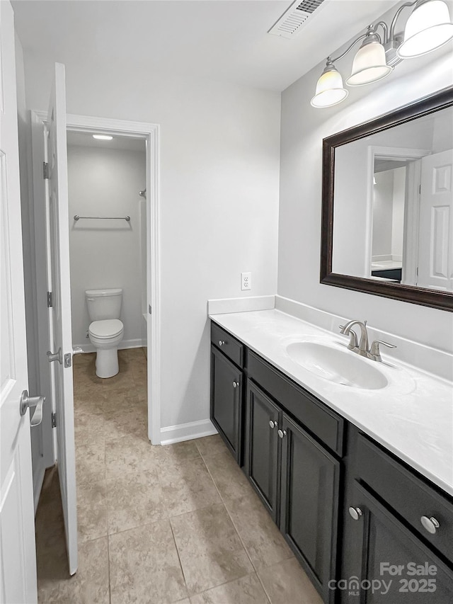 bathroom featuring vanity, visible vents, toilet, tile patterned floors, and baseboards