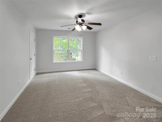 spare room featuring ceiling fan, carpet, and baseboards
