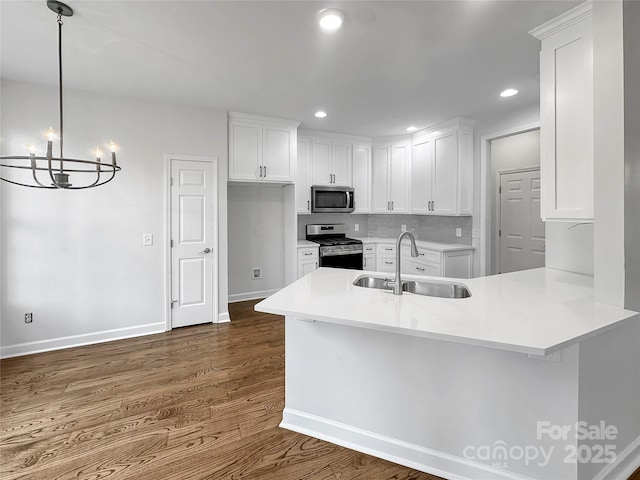 kitchen with a sink, dark wood finished floors, white cabinets, and stainless steel appliances