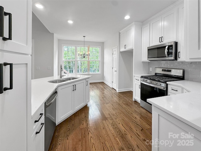 kitchen featuring white cabinets, a sink, light countertops, dark wood finished floors, and stainless steel appliances