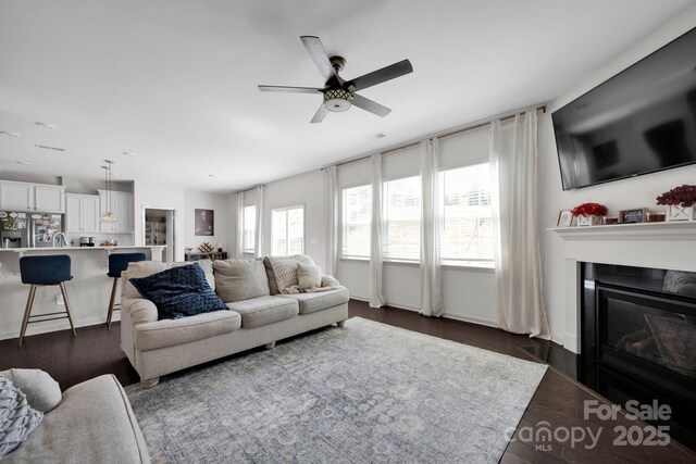 15127 Oleander Dr, Charlotte, NC 28278 - living area featuring dark wood-style flooring, a ceiling fan, and a glass covered fireplace