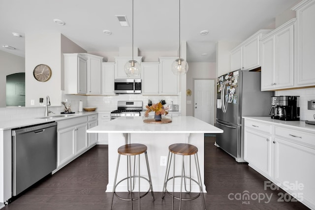 15127 Oleander Dr, Charlotte, NC 28278 - kitchen with visible vents, a sink, appliances with stainless steel finishes, a kitchen bar, and decorative backsplash