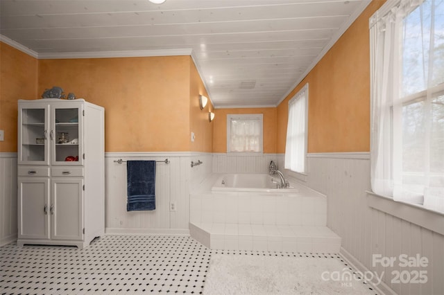 full bath featuring a garden tub, a wainscoted wall, and crown molding