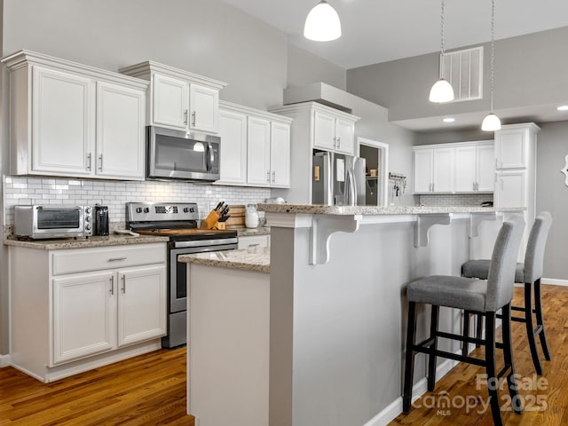 218 Little Man Dr, Boiling Springs, SC 29316 - kitchen with visible vents, appliances with stainless steel finishes, white cabinetry, decorative backsplash, and a toaster
