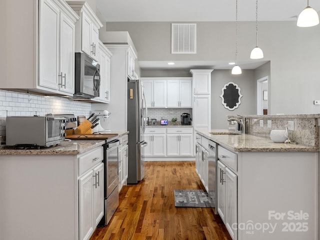 218 Little Man Dr, Boiling Springs, SC 29316 - kitchen featuring white cabinets, visible vents, decorative backsplash, stainless steel appliances, and a sink