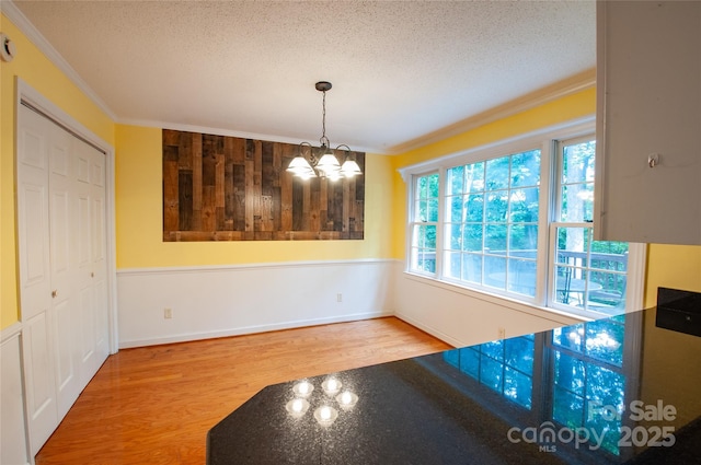 2540 Heritage Cir, Statesville, NC 28625 - unfurnished dining area featuring a textured ceiling, a chandelier, crown molding, and wood finished floors