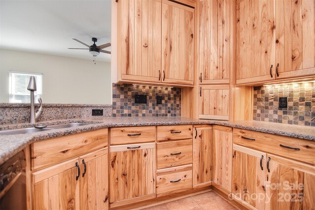 kitchen featuring light brown cabinetry, ceiling fan, a sink, and tasteful backsplash