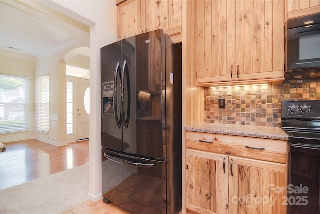 kitchen with visible vents, arched walkways, black appliances, light brown cabinets, and ornamental molding