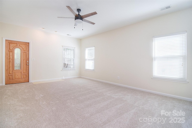 unfurnished room with baseboards, visible vents, light carpet, and ceiling fan